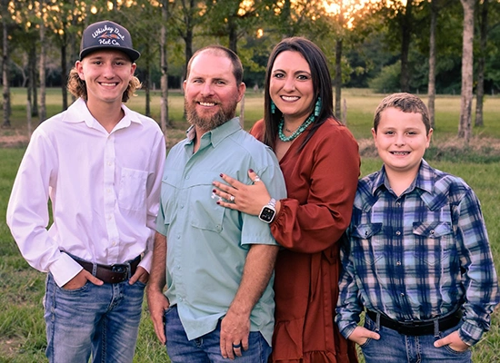 Family portrait of the Ross family, embodying the values of Ross Homes & Drafting, with members standing together in a natural setting, symbolizing their commitment to building homes and family connections.